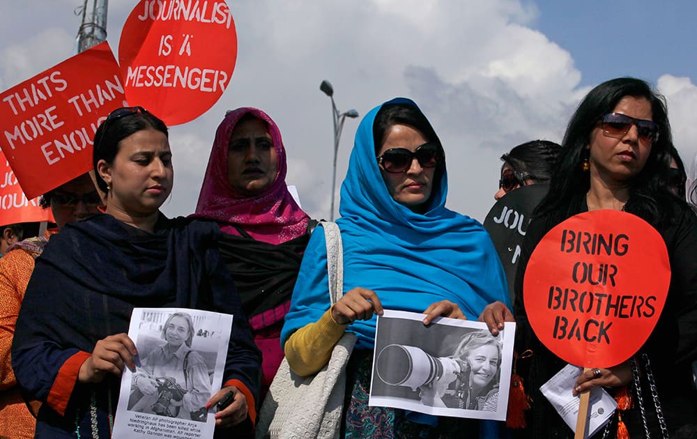 Pakistani journalists hold pictures of Associated Press photographer Anja Niedringhaus, 48, who was killed April 4, 2014 in Afghanistan, during a demonstration in Islamabad, Pakistan.