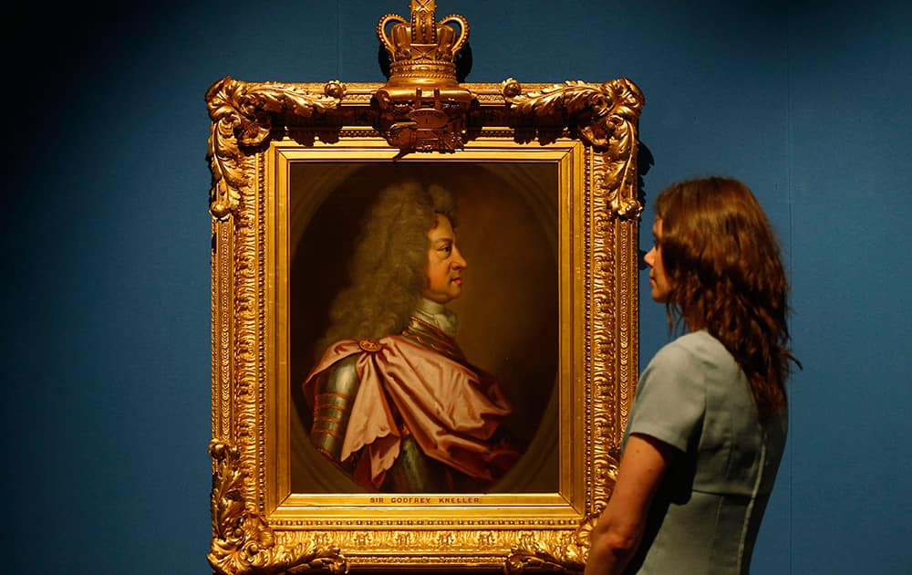 A gallery employee poses with the 1715 painting of King George I by Sir Godfrey Kneller on display in an exhibition `The First Georgians : Art and Monarchy 1714-1760` at The Queen`s Gallery in Buckingham Palace, London.