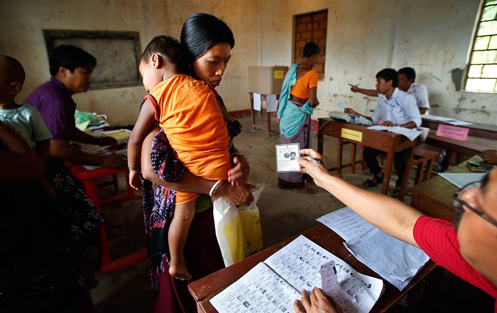 An election official checks the identity card of a voter during the first phase of elections in Agartala, in the northeastern state of Tripura.