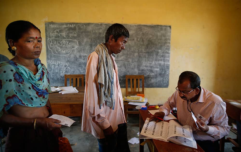 A polling officer looks for the name of a voter in the registered voter list during the first phase of elections in Agartala, in the northeastern state of Tripura.