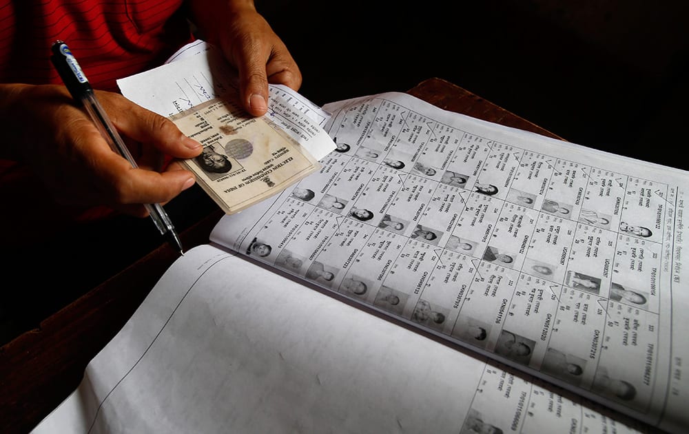 An election official checks the identity of a voter during the first phase of elections in Agartala, in the northeastern state of Tripura.