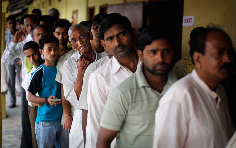 People stand in line to cast their votes during the first phase of elections in Dibrugarh, in the northeastern state of Assam.