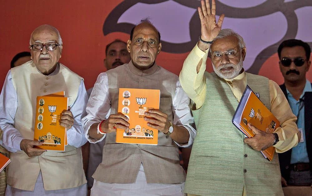 Bharatiya Janata Party (BJP)`s prime ministerial candidate Narendra Modi, right, party president Rajnath Singh, center, and senior leader Lal Krishna Advani release the party manifesto in New Delhi.