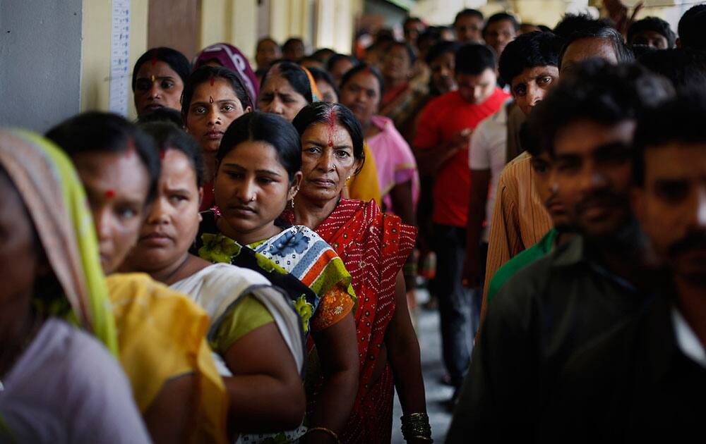 Voters wait in queues to cast their votes during the first phase of elections in Dibrugarh, in the northeastern state of Assam.