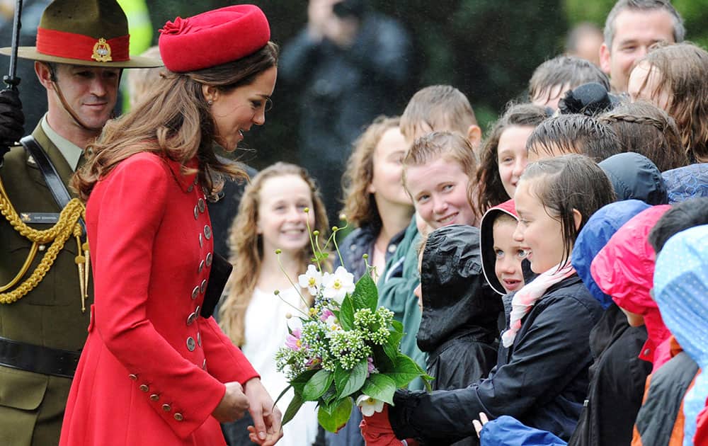 Britain`s Kate, the Duchess of Cambridge receives a bouquet of flowers from school children at the official welcome ceremony at Government House, in Wellington, New Zealand.