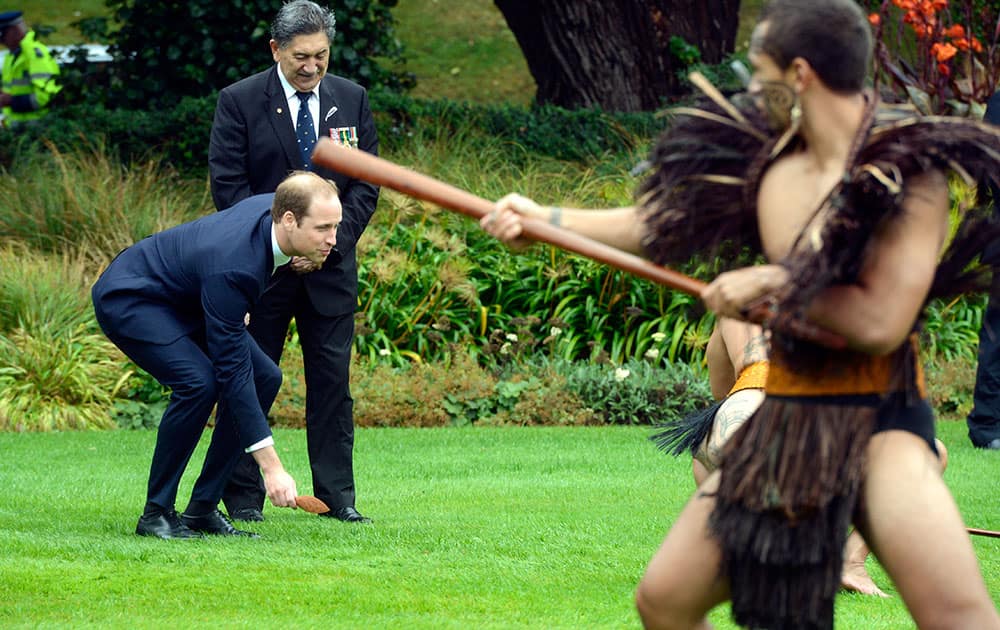 Britain`s Prince Willam, left, with Maori Elder Lewis Moeau picks up a challenge made by a Maori warrior, at the official welcome ceremony for William and his wife Kate, at Government House, in Wellington.
