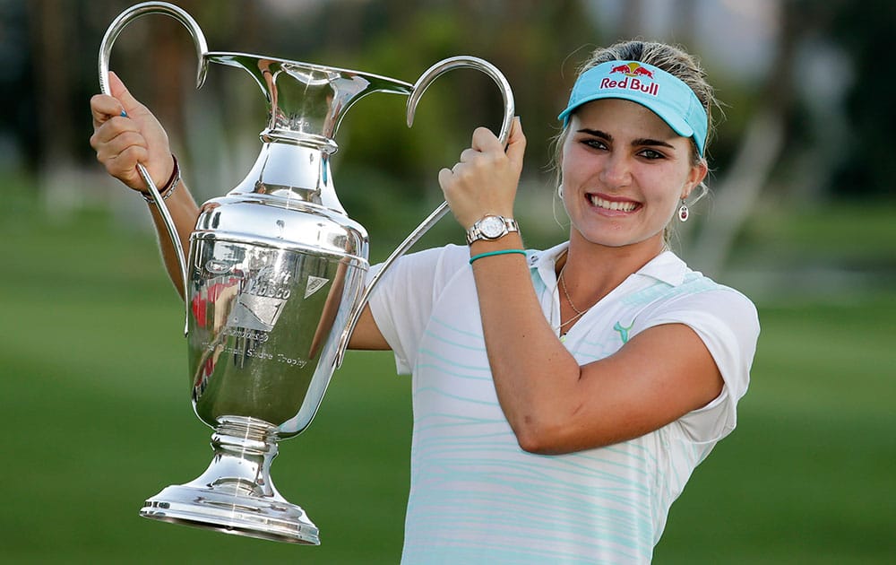 Lexi Thompson holds up the trophy after winning the Kraft Nabisco Championship golf tournament.