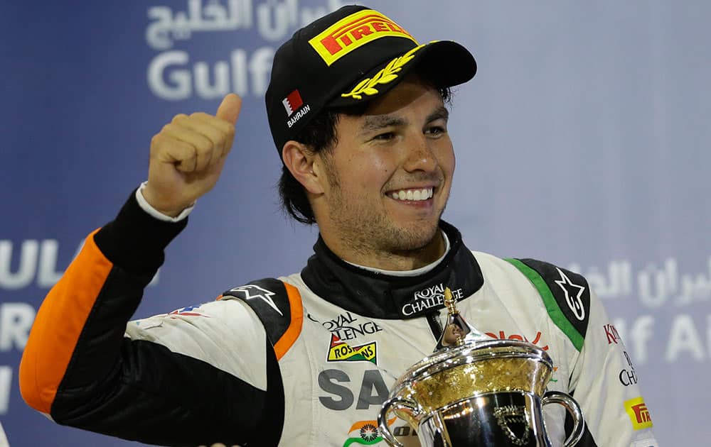 Third place Force India driver Sergio Perez of Mexico holds his trophy on the podium after the Bahrain Formula One Grand Prix at the Bahrain International Circuit in Sakhir, Bahrain.