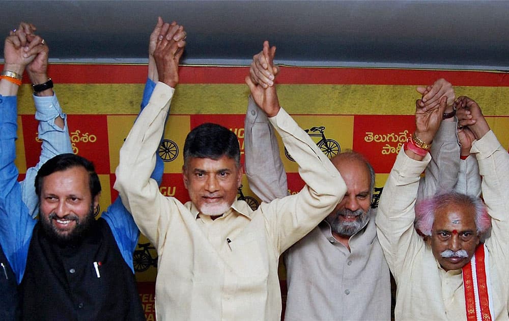 BJP leader Prakash Javadekar join hands with TDP supremo Chandrababu Naidu with other TDP legislators after the two paties aanounced an alliance for the Lok Sabha polls in Hyderabad.