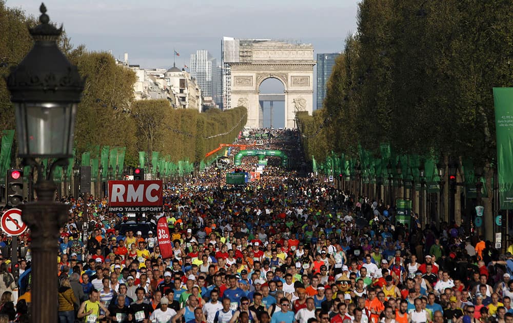 Runners make their way down the Champs Elysees avenue at the start of the 38th Paris Marathon, in Paris.