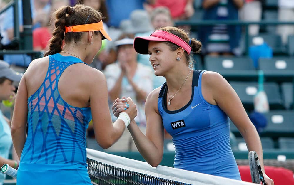 Belinda Bencic, of Switzerland, at left, shakes hands with Jana Cepelova, of slovakia, after a match during the Family Circle Cup tennis tournament in Charleston, S.C.