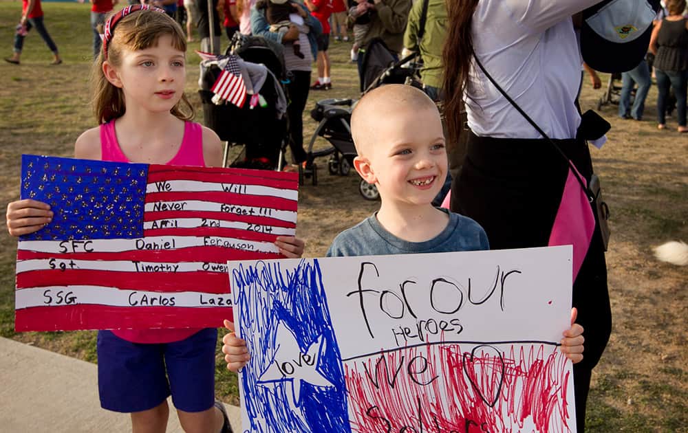 Emma Gill, 9, and her brother Kyle Gill, 6, participate in a tribute walk for the victims of Wednesday`s shooting at Fort Hood, at Lions Club Park in Killeen, Texas.