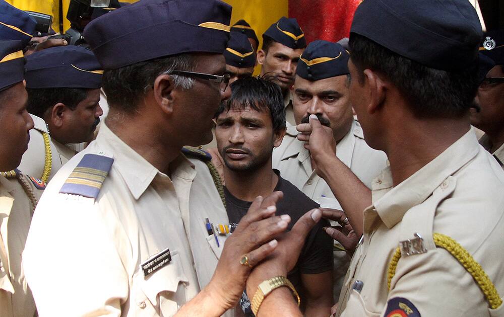 Police officials escort one of the four convicts in a gang rape case to a court in Mumbai. An Indian court on Friday sentenced to death three men who raped a photojournalist inside an abandoned textile mill in the financial hub of Mumbai last year. A fourth defendant was sentenced to life in prison, Nikam said.