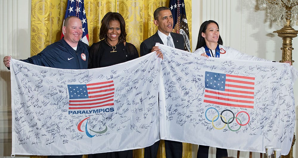 President Barack Obama and first lady Michelle Obama are presented with flags signed by the entire US Olympic team during a ceremony in the East Room of White House in Washington.
