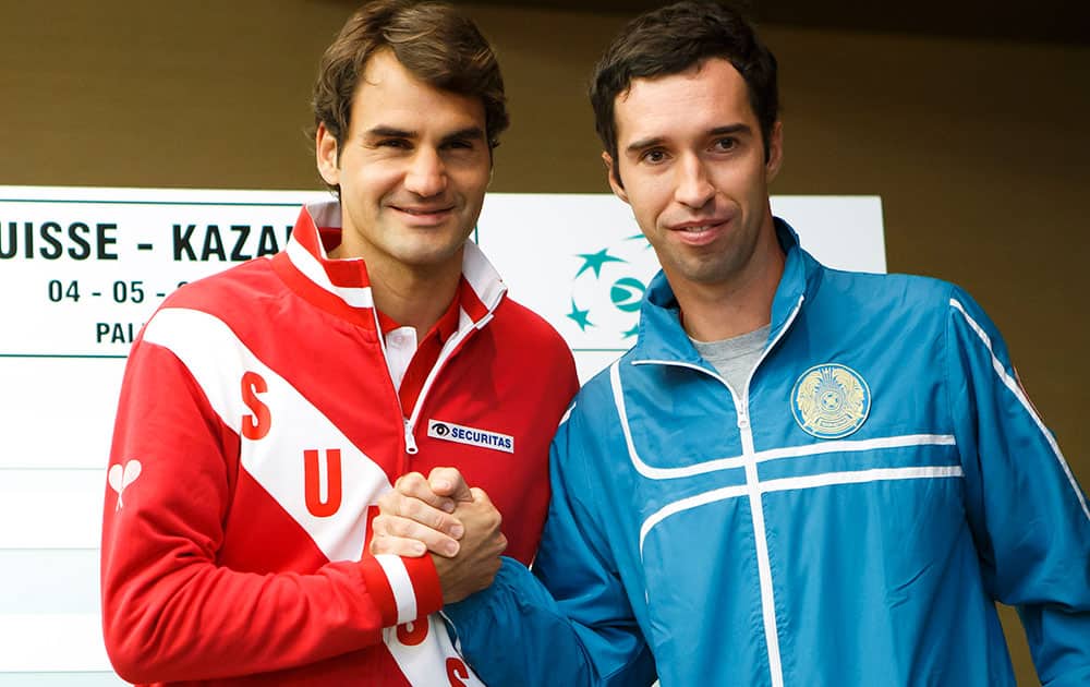 Roger Federer, left, of Switzerland, poses with Mikhail Kukushkin, right, of Kazakhstan, after the draw prior to the Davis Cup World Group quarterfinals between Switzerland and Kazakhstan, in Geneva, Switzerland.