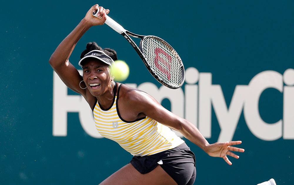 Venus Williams returns to Chanelle Scheepers, of South Africa, during the Family Circle Cup tennis tournament in Charleston, S.C.