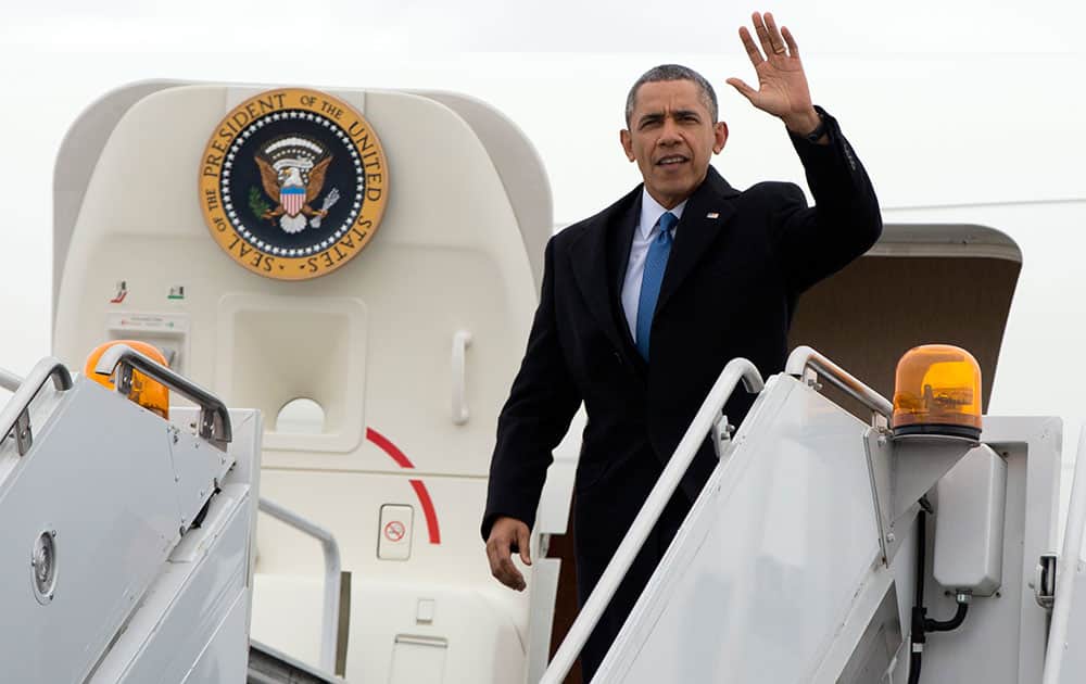 President Barack Obama waves as he arrives at Chicago`s O`Hare International Airport on Air Force One, in Chicago, as he travels to attend fundraising events.