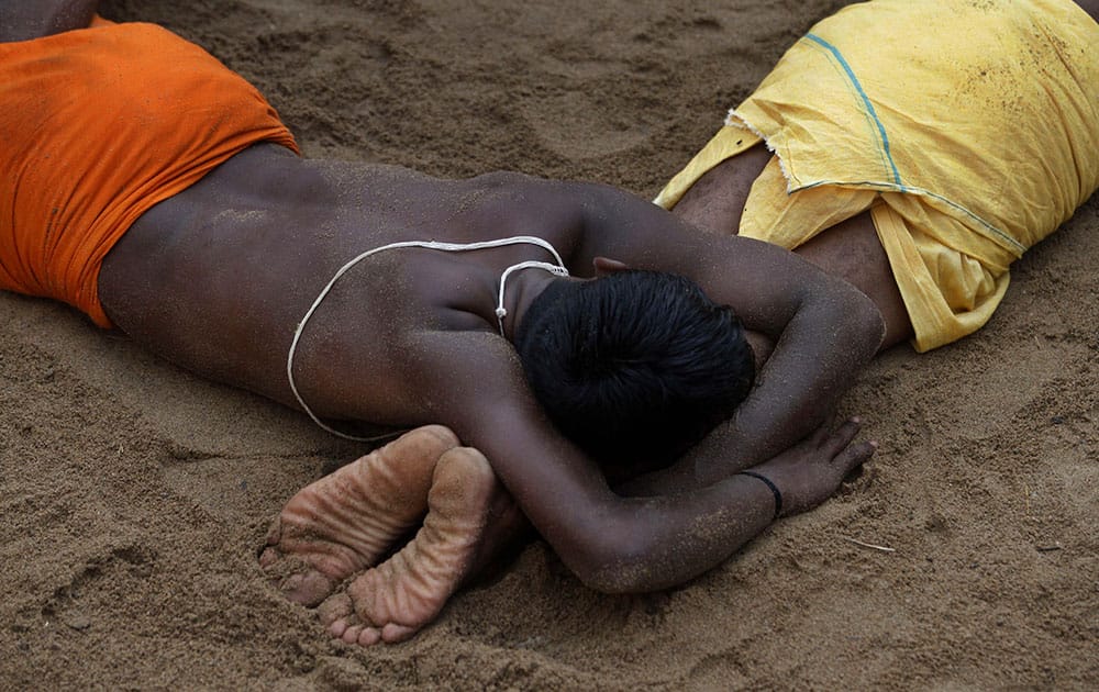 Indian villagers lie down on hot sand as part of a ritual as they participate in the annual Danda festival or the festival of self punishment at Kulagarh village in Ganjam district, Orissa state, India.