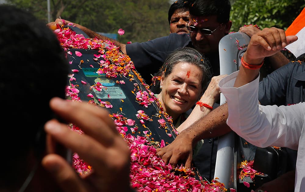Sonia Gandhi smiles to the crowd as she arrives to file her nomination papers for the upcoming general elections, in Rae Bareli.