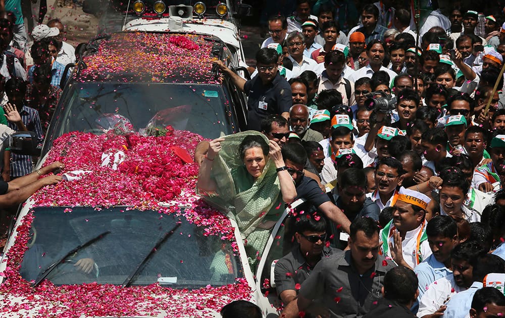 Sonia Gandhi adjusts her sari surrounded by a crowd, as she arrives to file her nomination papers for the upcoming general elections, in Rae Bareli.