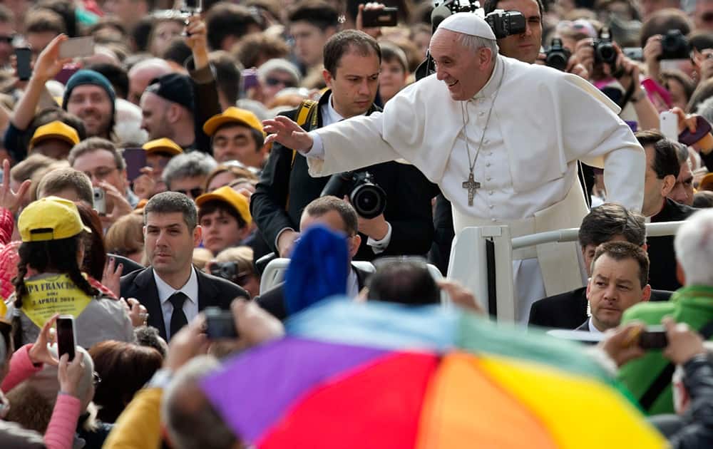 Pope Francis waves to faithful as he arrives for his weekly general audience in St. Peter`s Square at the Vatican.