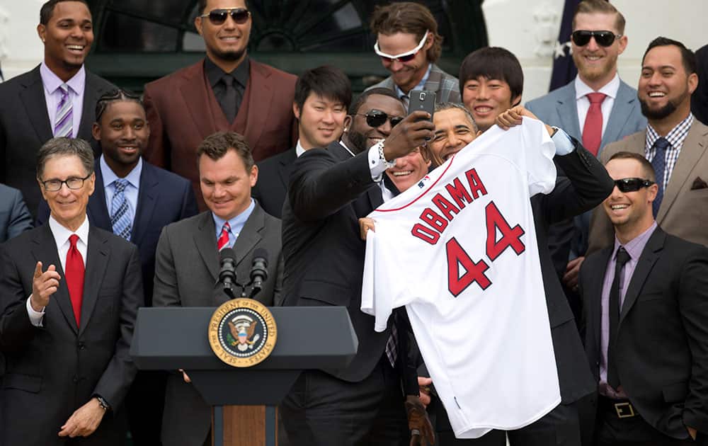 Boston Red Sox designated hitter David `Big Papi` Ortiz takes a selfie with President Barack Obama, holding a Boston Red Sox jersey, as the president Obama honored the 2013 World Series baseball champion Boston Red Sox.
