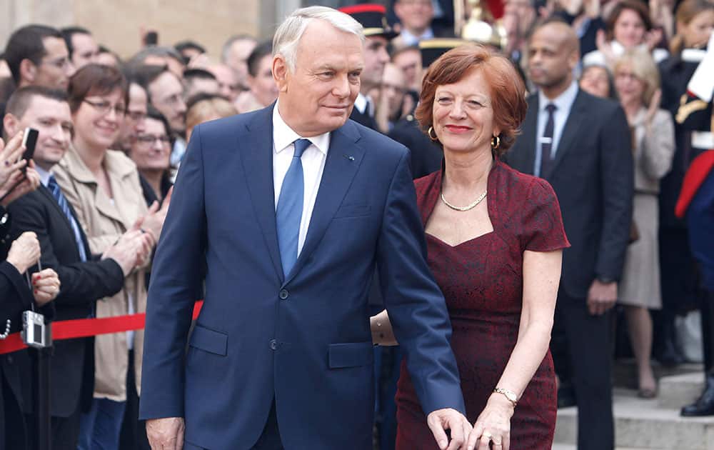 Outgoing French Prime Minister Jean-Marc Ayrault and his wife Brigitte leave after the takeover ceremony with new Prime Minister Manuel Valls, at the Prime Ministry in Paris.
