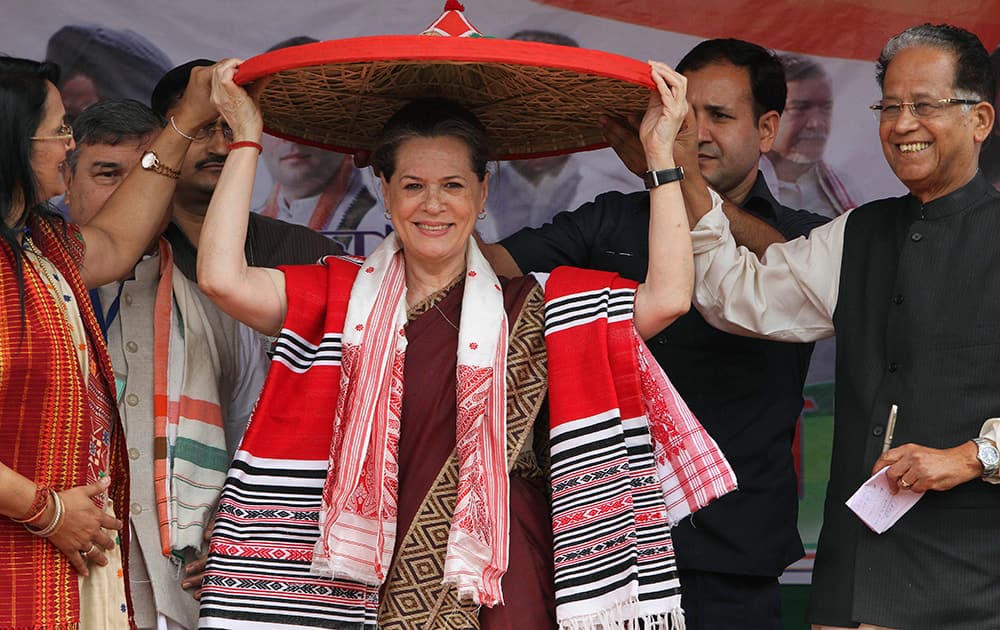 Sonia Gandhi holds an Assamese Japi, a traditional head gear that was presented to her during an election rally in Lakhimpur in the northeastern state of Assam.