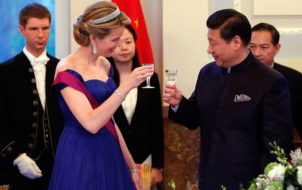 Belgium`s Queen Mathilde, second left, and China`s President Xi Jinping, second right, take part in a gala dinner at the Royal Palace of Laeken in Brussels.