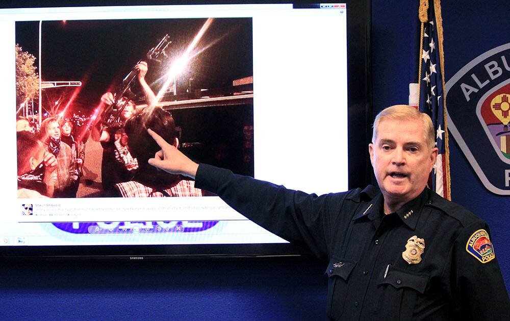Albuquerque Police Chief Gorden Eden shows the image of a man who brought a rifle to an hours` long protest over police shootings during a news conference in Albuquerque, N.M.