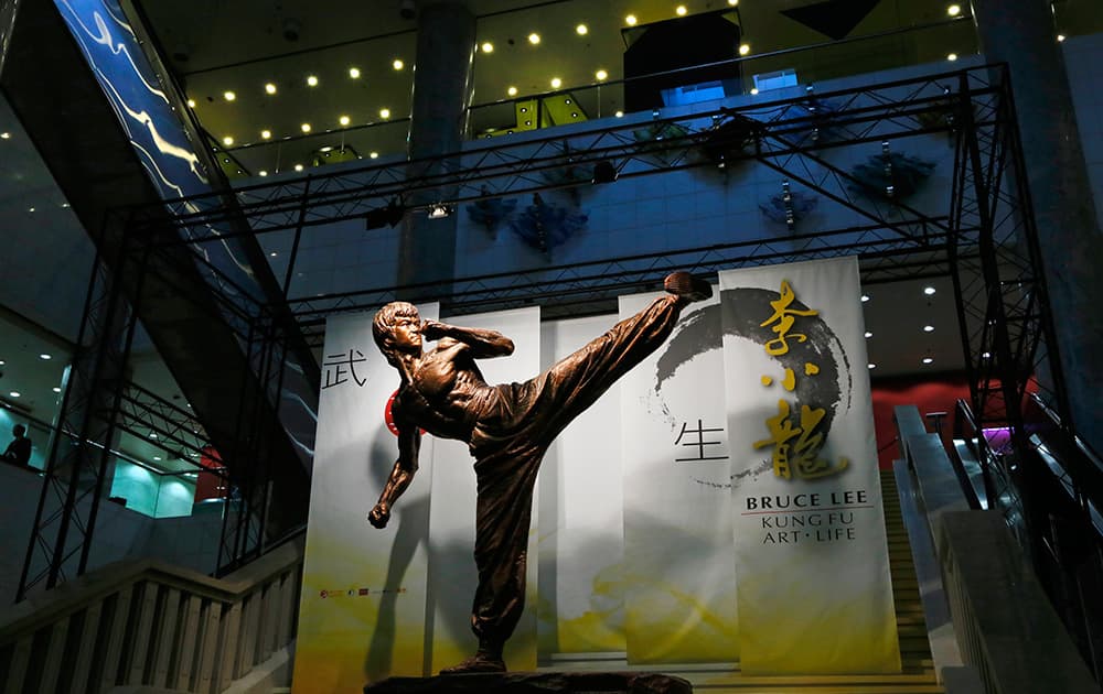 A man walks near a statue of pop culture icon Bruce Lee at Lee`s memorial exhibition at the Hong Kong Heritage Museum in Hong Kong, to mark the 40th anniversary of his death.