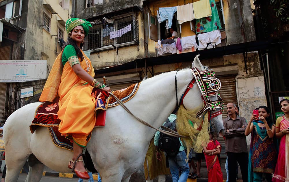 A woman dressed in traditional attire sits on a horse during a procession celebrating `Gudi Padwa`, or the Marathi new year, in Mumbai.