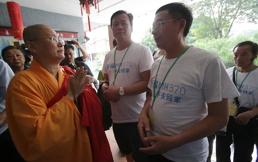 A Buddhist monk welcomes Chinese relatives of passengers on board the missing Malaysia Airlines Flight 370 as they arrive to pray at a Buddhist temple in Petaling Jaya, Malaysia.