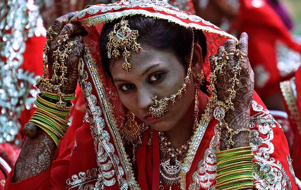 A bride adjusts her attire at a mass marriage where 35 Muslim couples got married in Ahmadabad.