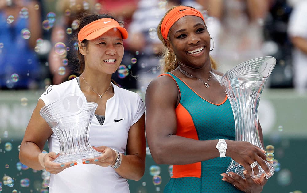Serena Williams, right, of the United States, and Li Na, of China, pose for photos after the trophy presentation for the women`s final at the Sony Open Tennis tournament in Key Biscayne, Fla.