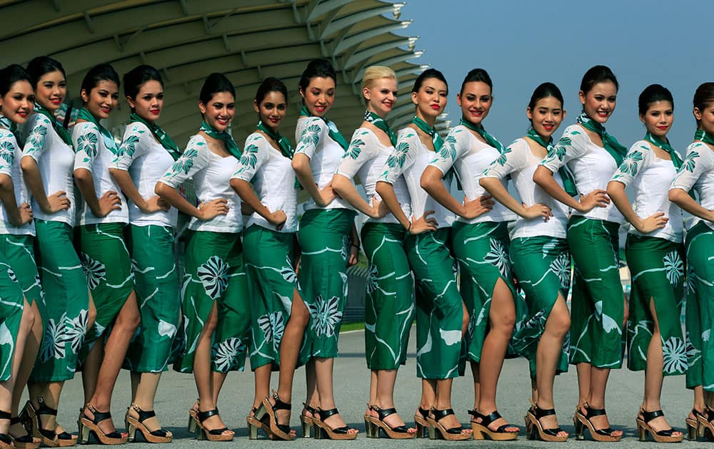 Grid girls pose for photos before the Malaysian Formula One Grand Prix at Sepang International Circuit in Sepang, Malaysia.