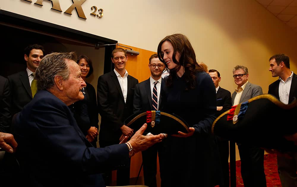 Former President George H.W. Bush, left, receives a tri-corner hat from actress Heather Lind, right, at a private screening of AMC`s new series TURN in Houston, Texas.