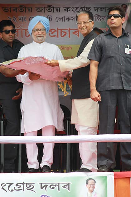 Assam Chief Minister Tarun Gogoi presents Assamese japi and gamocha to Prime Minister Manmohan Singh as he arrives at his first election rally in Sivasagar.