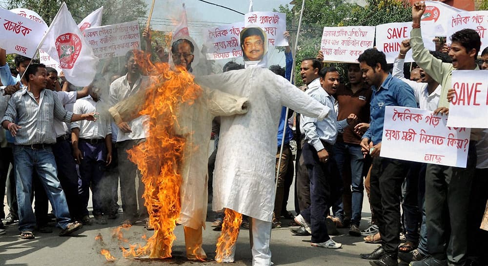 Activists of All Assam Students Union (AASU) burning effigies of Chief Minister of Assam Tarun Gogoi and Forest Minister of Assam Rikibul Hussain in Guwahati.
