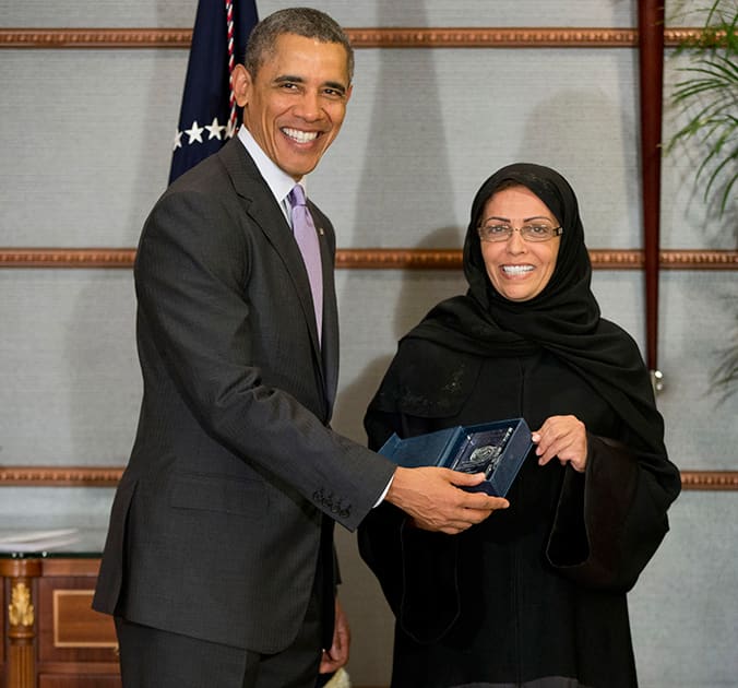 US President Barack Obama poses for photographers as he presents Dr. Maha Al-Muneef with the US Secretary of State`s International Woman of Courage Award in Riyadh, Saudi Arabia.