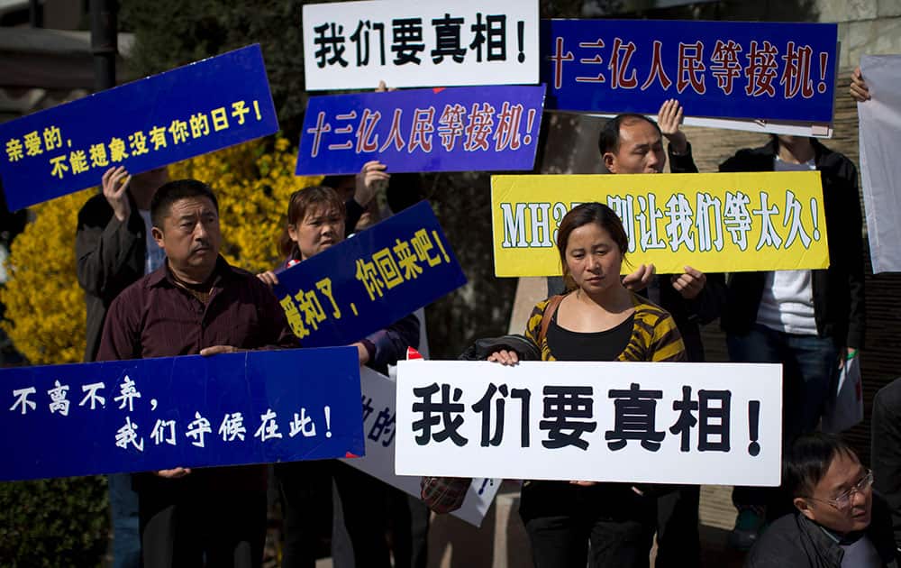 Relatives of Chinese passengers on board Malaysia Airlines Flight 370 hold boards with words, `We want the truth! MH370, do not let us wait too long! My dear, I can not imagine my life without you!` as they stage a protest against the airlines and the Malaysian government at a hotel in Beijing.