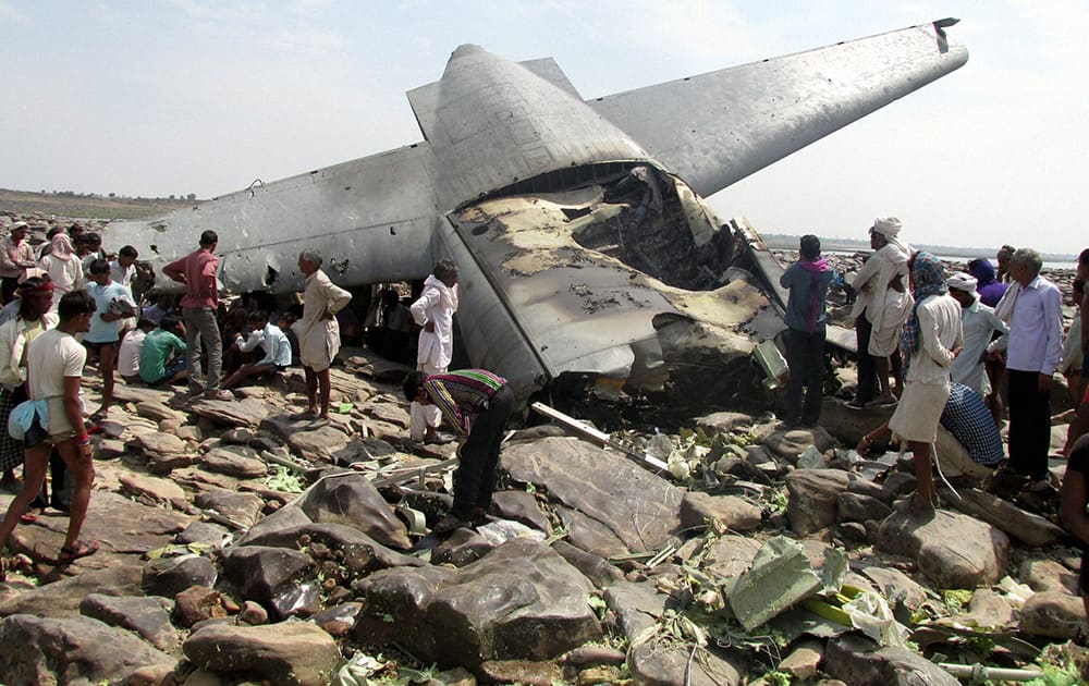 Villagers crowd around the debris of an Indian air force cargo plane that crashed near Karauli village in Madhya Pradesh. C-130J Hercules plane inducted into service just last year crashed during a training mission Friday, killing all five crew members in the latest in a series of accidents that have hit the Indian armed forces.