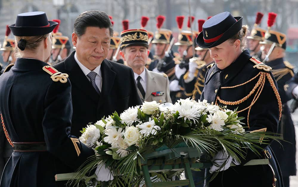 Chinese President Xi Jinping, second left, lays a wreath of flowers at the tomb of the Unknown Sodier in Paris.
