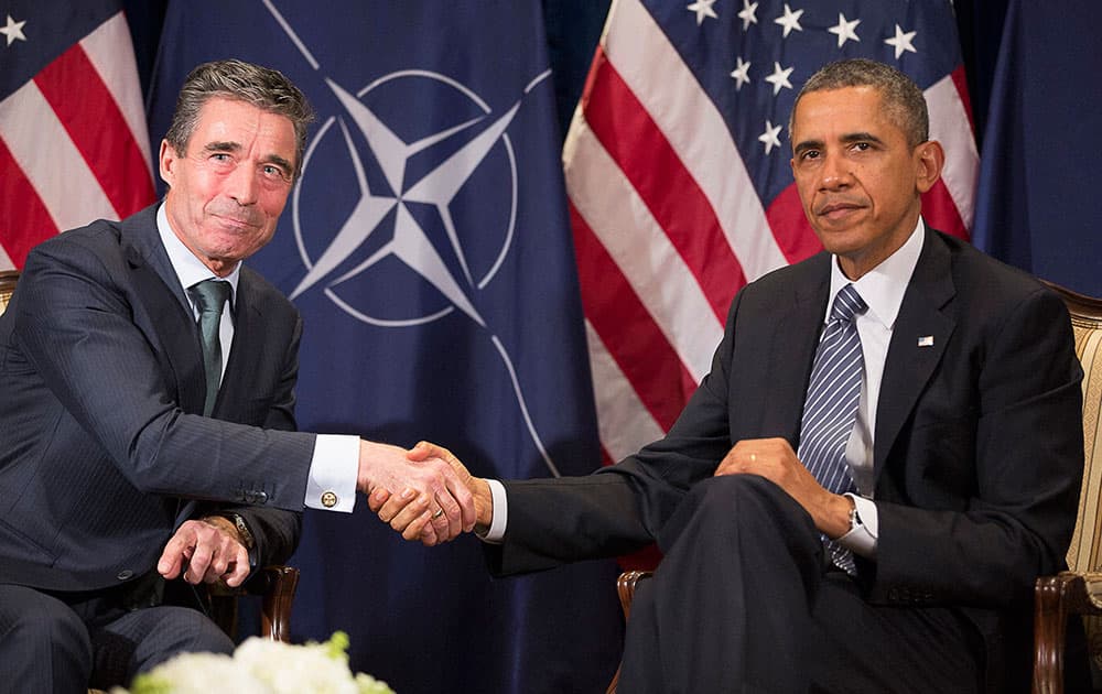 US President Barack Obama, right, shakes hands with NATO Secretary General Anders Fogh Rasmussen at a hotel in Brussels. President Obama is on a one day trip to Belgium to meet EU officials and visit the WWI Flanders Field Cemetery.