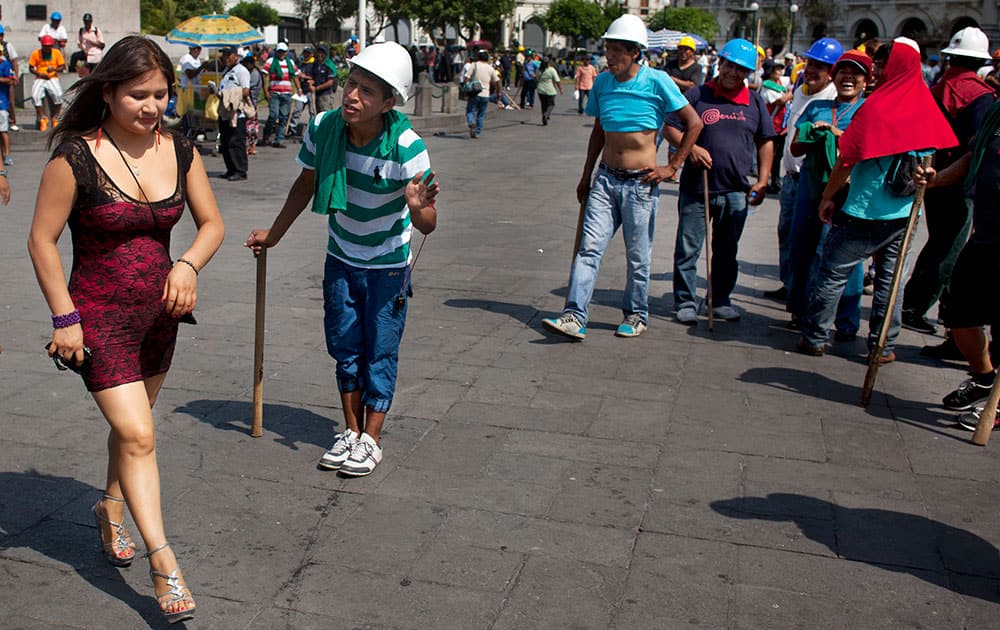 A miner flirts with a woman during a break while protesting in Lima, Peru. Into their seventh day of protesting, miners are asking the government to repeal regulations aimed at formalizing informal miners.