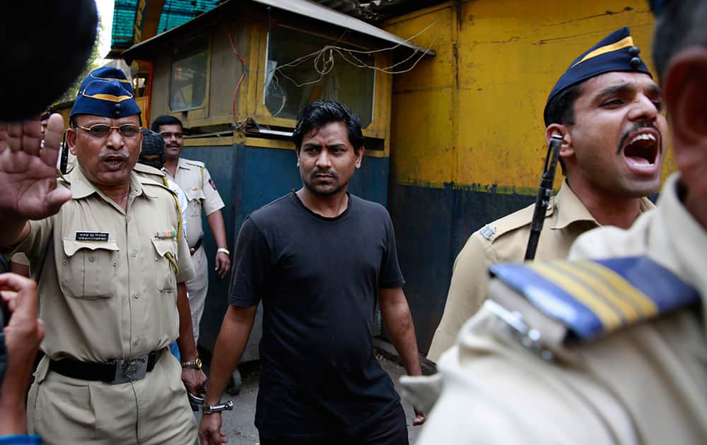 Police officers escort one of the four convicts in the gang rape of a photojournalist outside a prison to be taken to a court in Mumbai.
