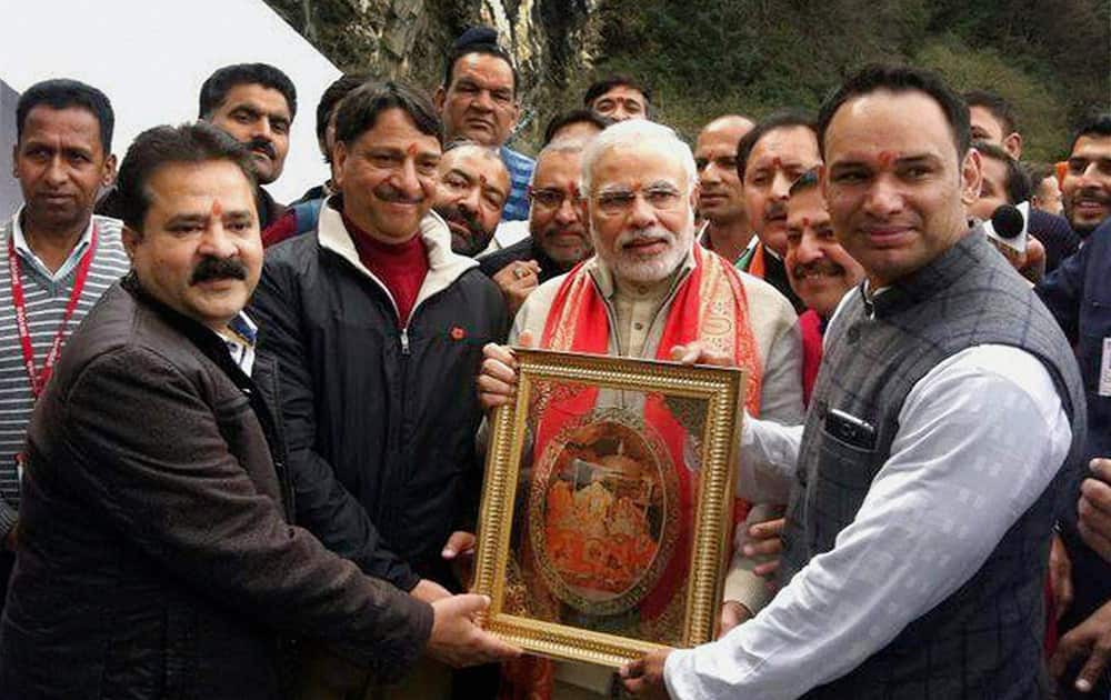 BJPs Prime Ministerial candidate Narendra Modi is presented a portrait of Mata Vaishno Devi during his visit to the shrine in Katra.