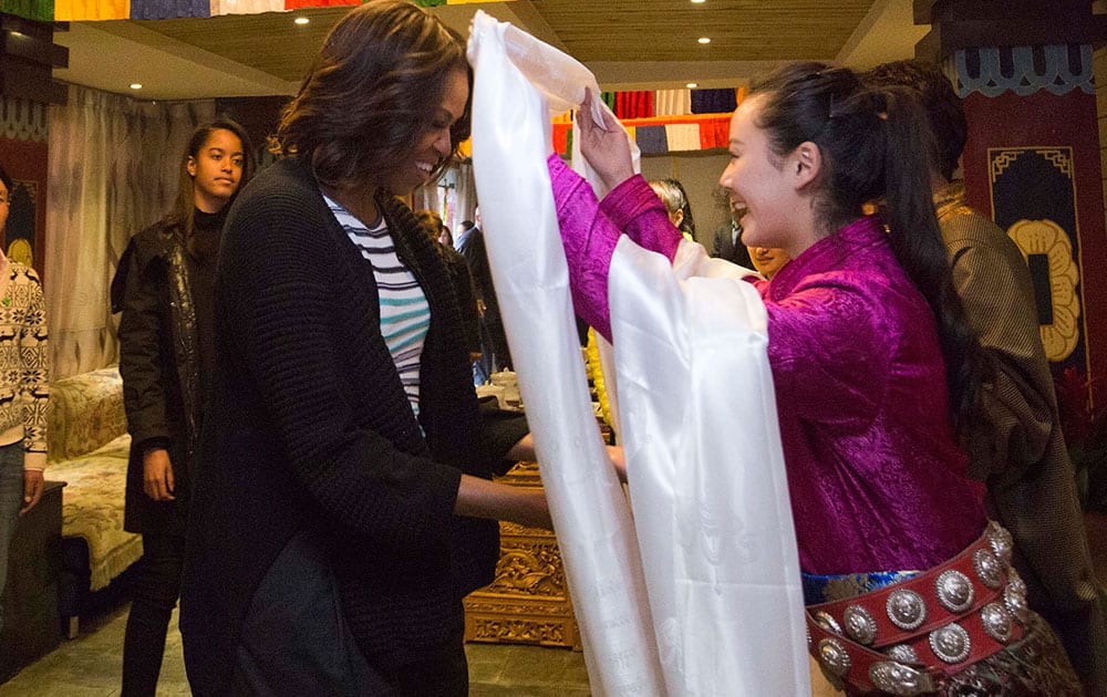 US first lady Michelle Obama receives a Tibetan scarf as she and her daughters Sasha, Malia, and mother Marian Robinson arrive to a Tibetan restaurant for lunch in Chengdu in southwest China`s Sichuan province.