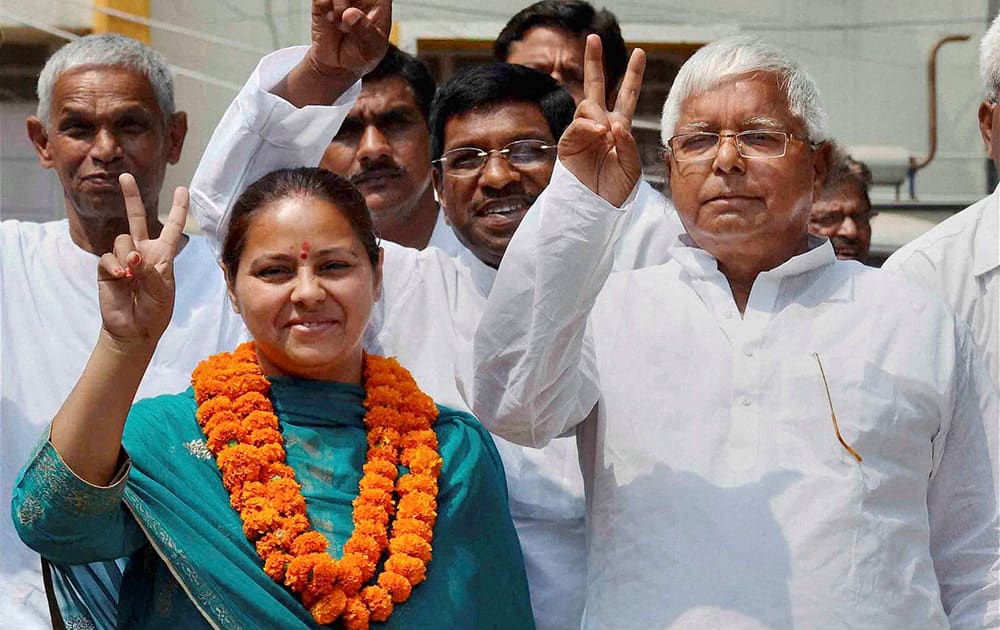 RJD chief Lalu Prasad along with his daughter and party candidate from Patliputra Misa Bharti and supporters wave victory sign after Bharti filed her nomination papers in Patna.