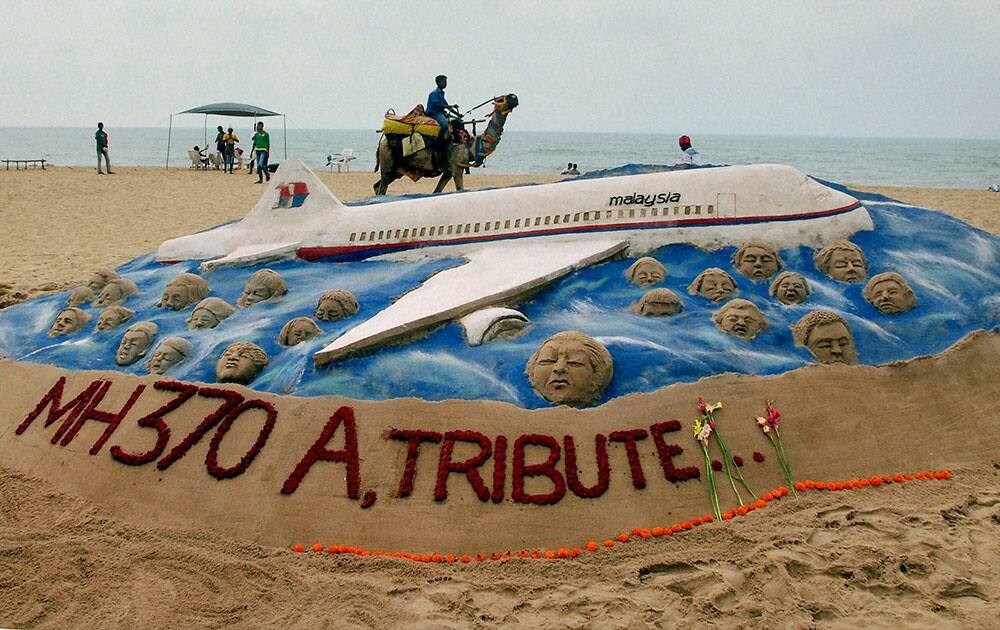 Sand artist Sudarsan Pattnaik creates a sand sculpture to pay tribute to the passenger of Malayasian Airlines MH370, at Puri beach of Odisha.